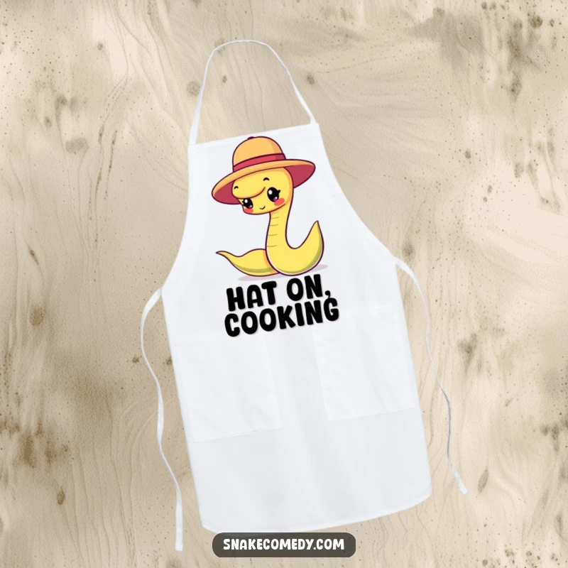 Funny snake character happily balancing a small round hat, printed on a functional apron for stylish and playful cooks.