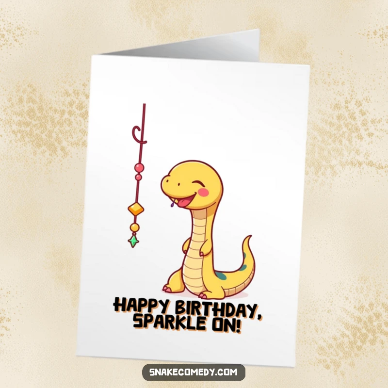 Funny Free Printable Birthday Card: A snake happily plays with a dangling sparkly charm, celebrating a birthday with joyful fascination.