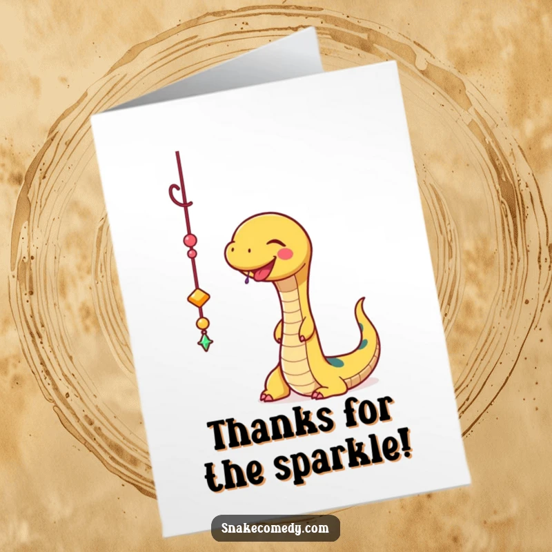 Funny Free Printable Thank You Card: A happy snake joyfully batting at a sparkly charm, conveying thanks with playful fascination.